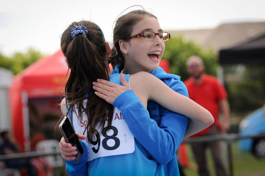 Two athletes hug after a race